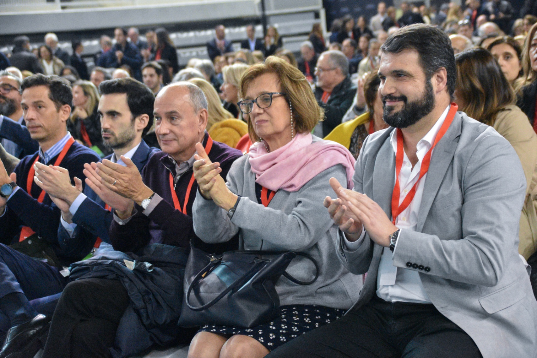 Participantes a aplaudir na plateia durante a sessão do congresso.