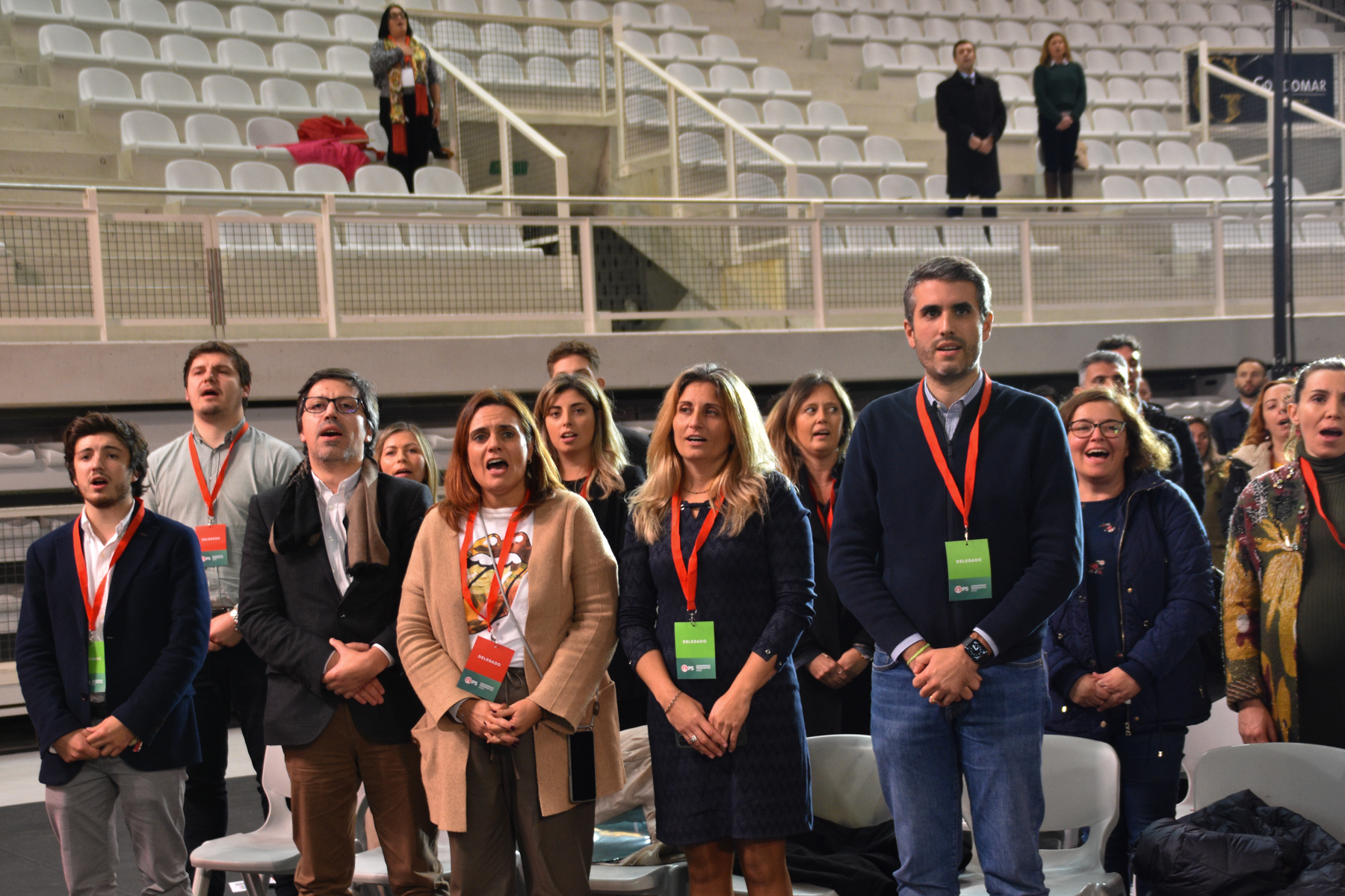 Delegados em pé num momento solene durante o congresso.